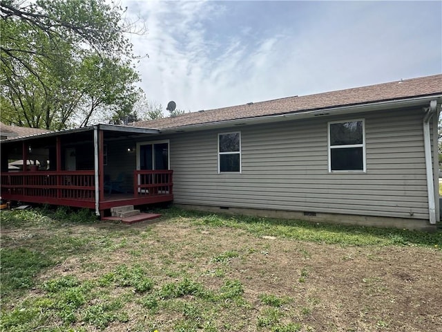 rear view of property with a wooden deck, a lawn, and crawl space
