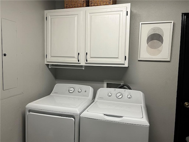 clothes washing area with electric panel, washer and clothes dryer, and cabinet space