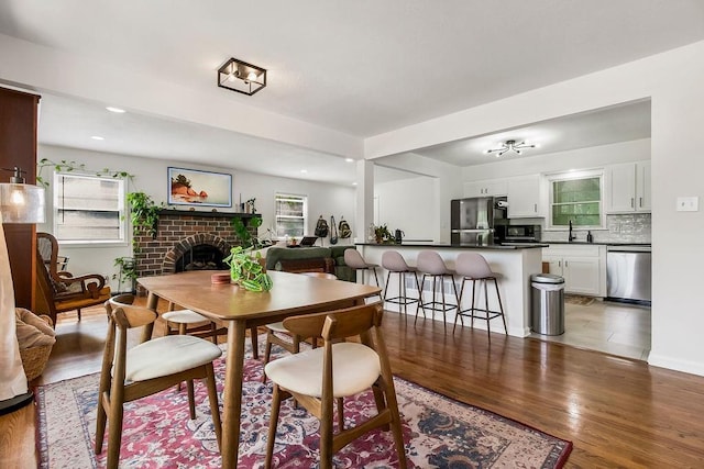 416 NE Carriage St, Lees Summit, MO 64064 - dining space with a brick fireplace, light wood-type flooring, and recessed lighting
