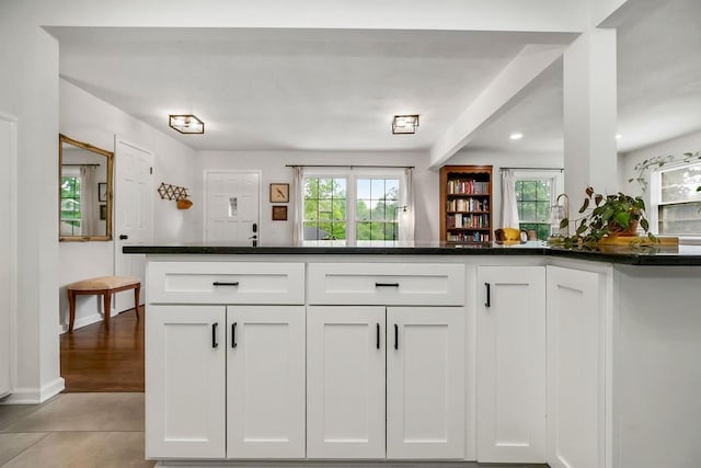 416 NE Carriage St, Lees Summit, MO 64064 - kitchen with white cabinets, dark countertops, light tile patterned floors, and baseboards
