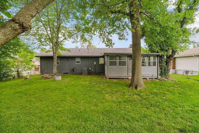416 NE Carriage St, Lees Summit, MO 64064 - rear view of property with a yard, central AC, a chimney, and board and batten siding