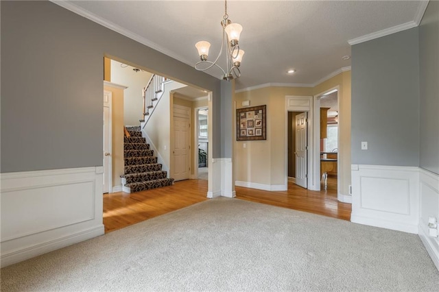 7428 N Smalley Ave, Kansas City, MO 64158 - empty room with carpet, stairs, crown molding, a chandelier, and a wainscoted wall