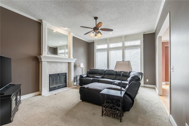 7428 N Smalley Ave, Kansas City, MO 64158 - living room featuring crown molding, carpet floors, a ceiling fan, a tile fireplace, and a textured ceiling
