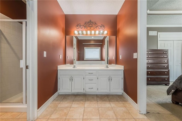 7428 N Smalley Ave, Kansas City, MO 64158 - bathroom featuring a textured ceiling, a shower stall, tile patterned flooring, double vanity, and baseboards