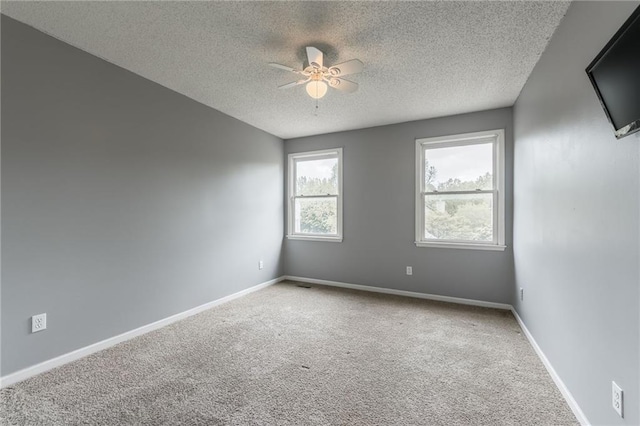 7428 N Smalley Ave, Kansas City, MO 64158 - carpeted empty room with a textured ceiling, a ceiling fan, and baseboards
