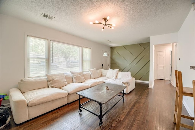 living room featuring wood finished floors, a chandelier, a textured ceiling, and baseboards