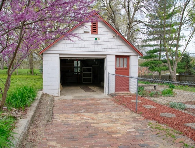 detached garage with fence and driveway