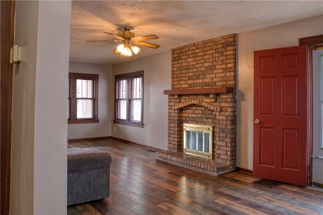 unfurnished living room featuring a textured ceiling, ceiling fan, a fireplace, wood-type flooring, and baseboards