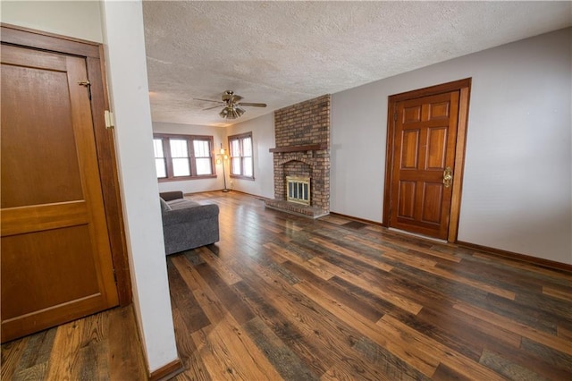 unfurnished living room with ceiling fan, wood finished floors, a textured ceiling, and a fireplace