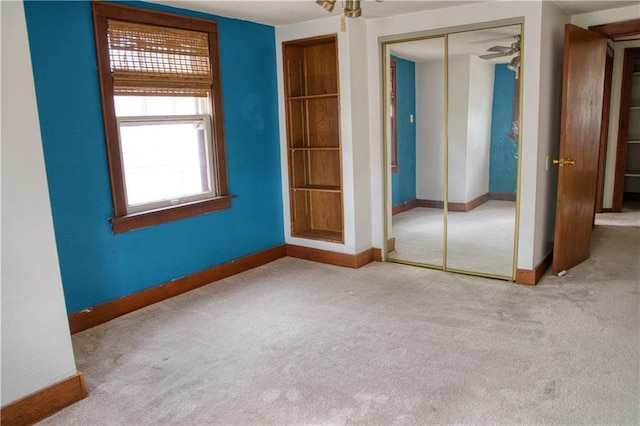 unfurnished bedroom with a closet, carpet flooring, and baseboards