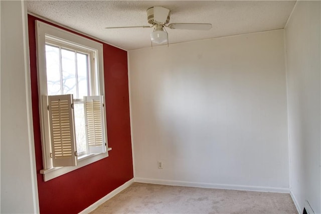 unfurnished room with a ceiling fan, light carpet, baseboards, a baseboard radiator, and a textured ceiling