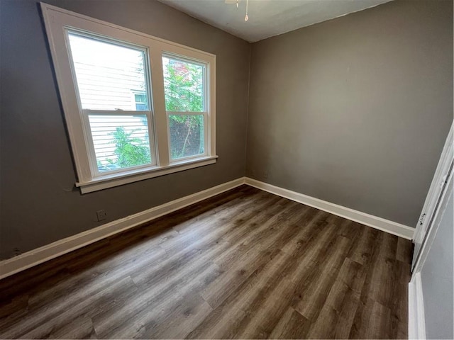 5702 Euclid Ave, Kansas City, MO 64130 - unfurnished room with baseboards and dark wood-style flooring