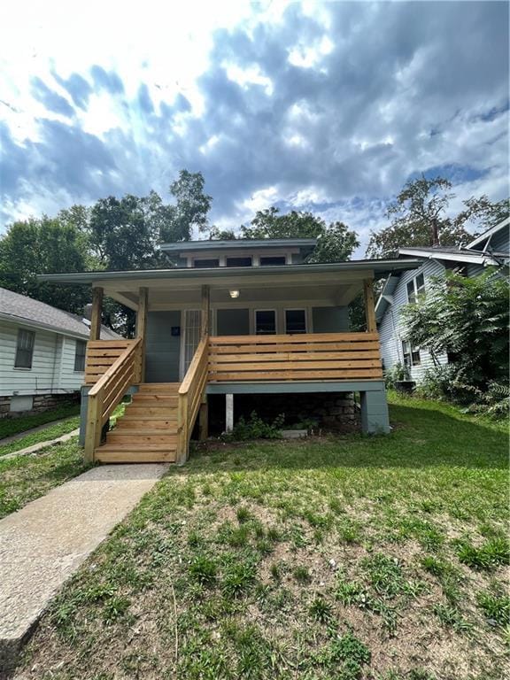 5702 Euclid Ave, Kansas City, MO 64130 - bungalow-style house with a porch, stairs, and a front yard