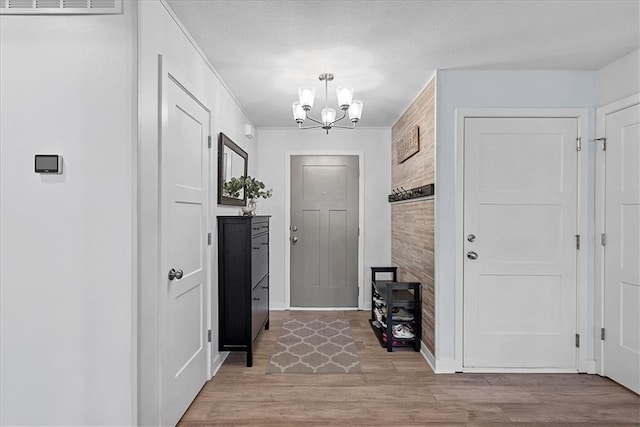 interior space featuring baseboards, light wood finished floors, and a chandelier