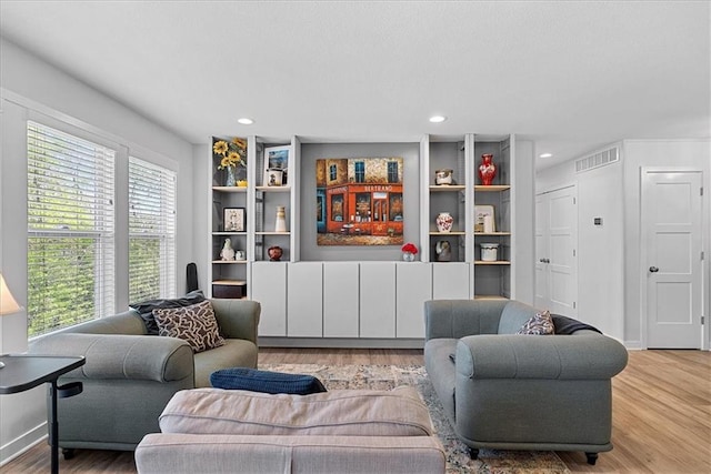 living area featuring light wood-type flooring, recessed lighting, and visible vents