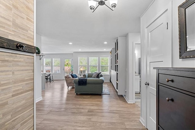 living area with light wood-style floors, recessed lighting, baseboards, and a notable chandelier