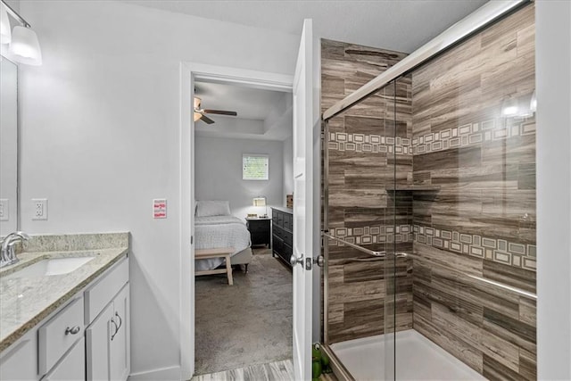 full bath featuring ceiling fan, a stall shower, vanity, baseboards, and ensuite bathroom