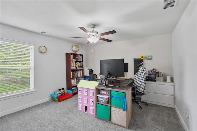 carpeted office featuring baseboards, ceiling fan, and visible vents