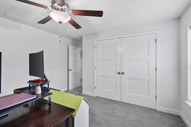 carpeted office space featuring a ceiling fan, baseboards, and visible vents