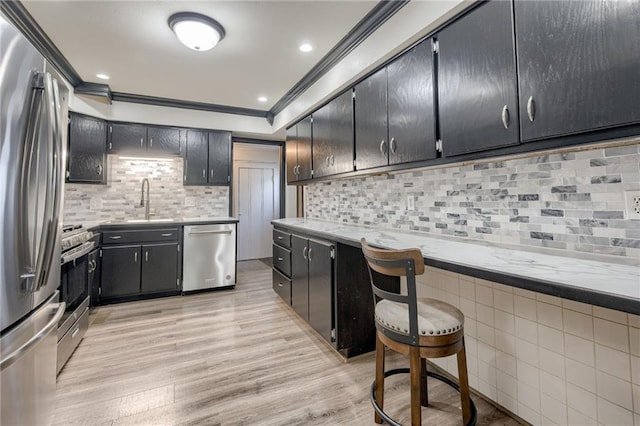 kitchen with stainless steel appliances, crown molding, a sink, backsplash, and light countertops