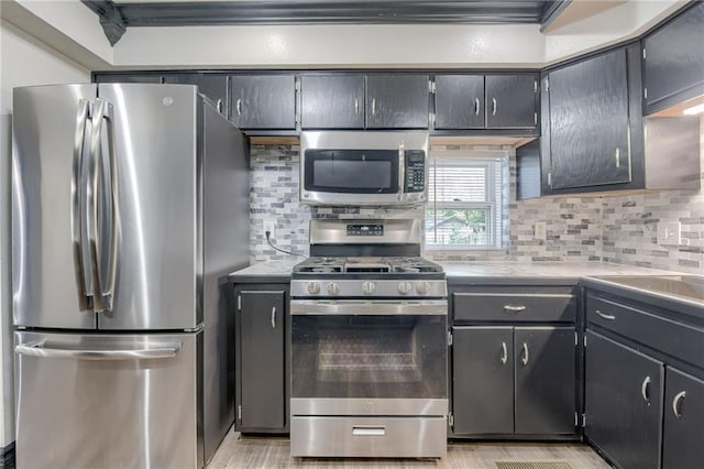kitchen with appliances with stainless steel finishes, decorative backsplash, light countertops, and light wood-style flooring
