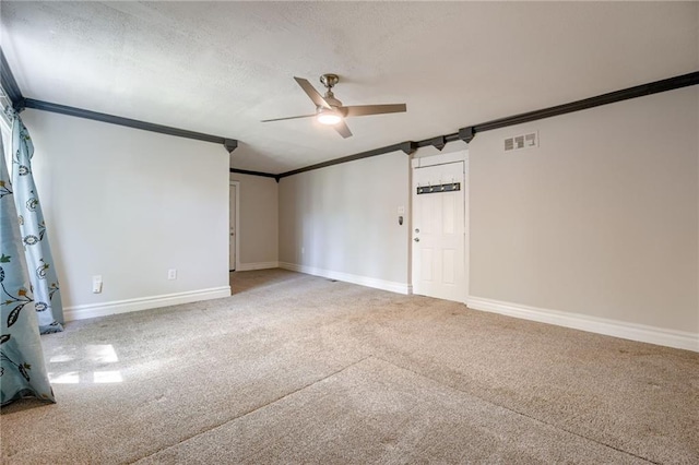 carpeted spare room featuring crown molding, ceiling fan, and baseboards