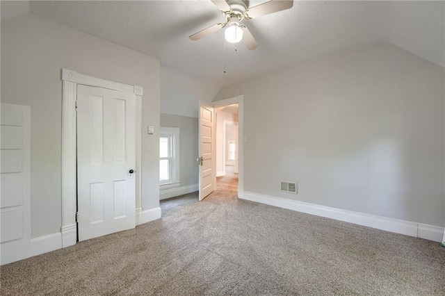 unfurnished bedroom featuring vaulted ceiling, carpet, baseboards, and ceiling fan