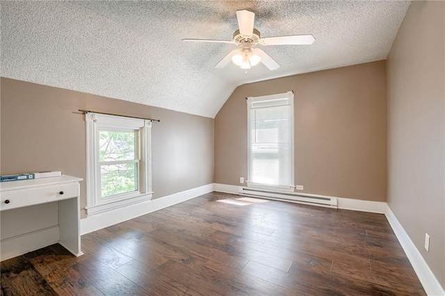 additional living space with a baseboard heating unit, a textured ceiling, ceiling fan, vaulted ceiling, and wood finished floors