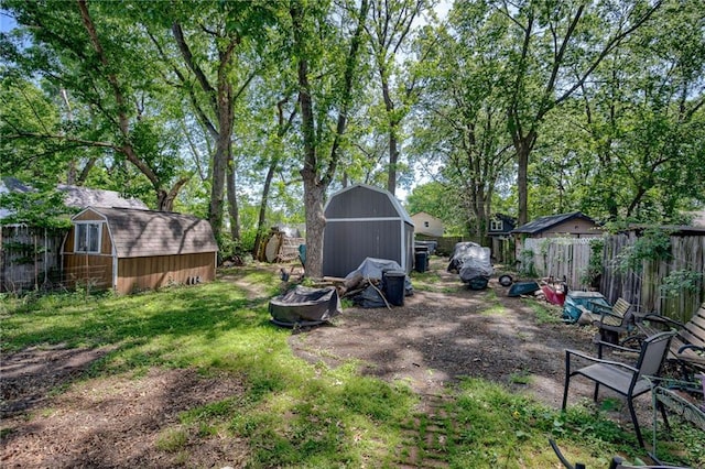 fenced backyard with a shed and an outbuilding