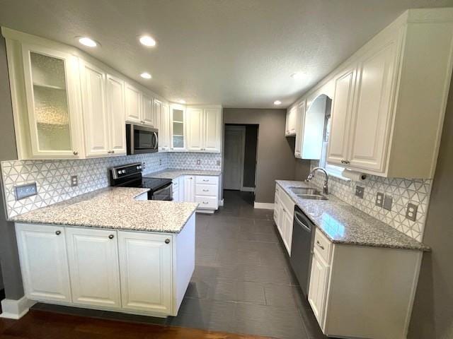 3106 Mill Ct, Pittsburg, KS 66762 - kitchen with stainless steel appliances, a peninsula, a sink, baseboards, and decorative backsplash