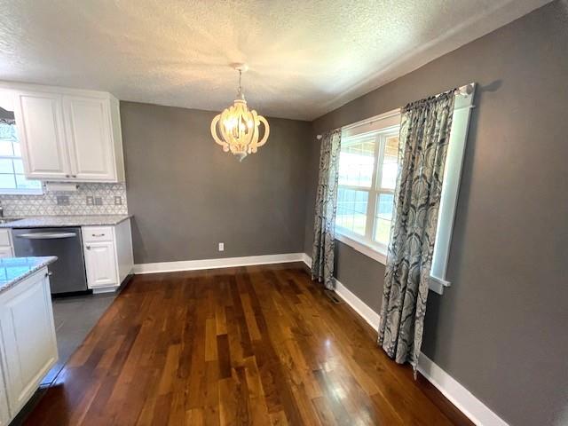 3106 Mill Ct, Pittsburg, KS 66762 - kitchen with stainless steel dishwasher, a chandelier, white cabinetry, light countertops, and dark wood finished floors