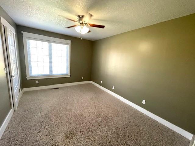 3106 Mill Ct, Pittsburg, KS 66762 - carpeted spare room featuring a textured ceiling, a ceiling fan, and baseboards