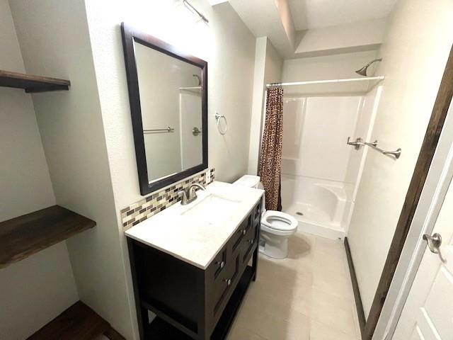 3106 Mill Ct, Pittsburg, KS 66762 - bathroom with toilet, a shower stall, vanity, and tasteful backsplash