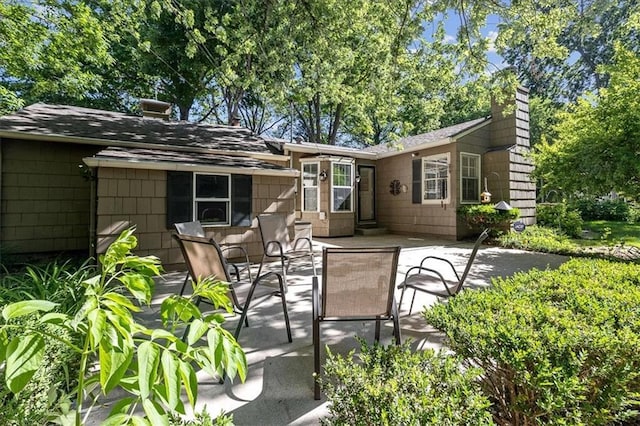 1215 W 69th Ter, Kansas City, MO 64113 - back of property featuring a patio area, a chimney, and roof with shingles