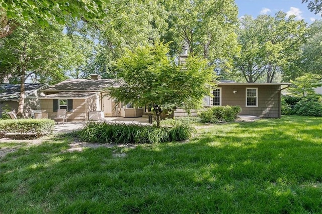 1215 W 69th Ter, Kansas City, MO 64113 - rear view of property featuring a patio area and a lawn