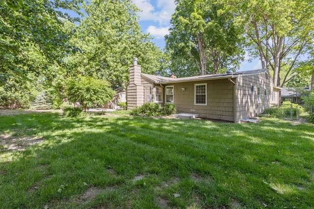 1215 W 69th Ter, Kansas City, MO 64113 - rear view of property with a chimney