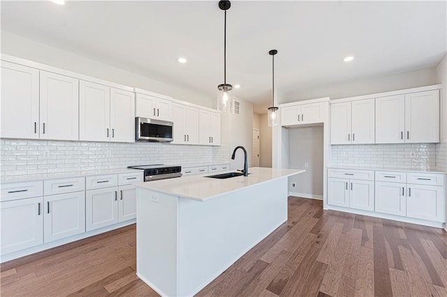 16611 Lawson St, Olathe, KS 66062 - kitchen with light wood finished floors, tasteful backsplash, stainless steel microwave, and a sink