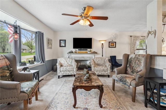 13613 Lowell Ave, Grandview, MO 64030 - carpeted living area with a ceiling fan, a textured ceiling, a tiled fireplace, and baseboards