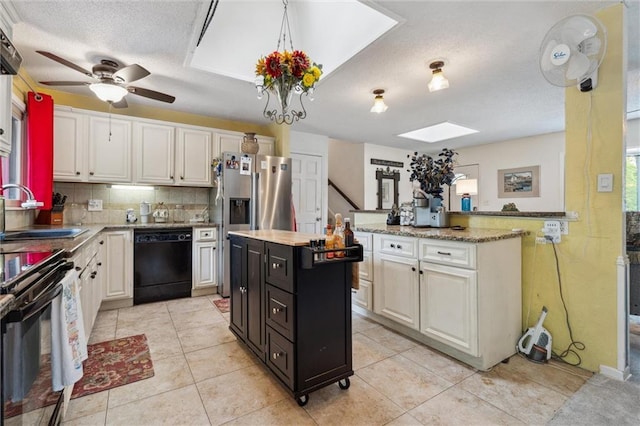 13613 Lowell Ave, Grandview, MO 64030 - kitchen featuring dishwasher, a sink, a kitchen island, a textured ceiling, and a skylight