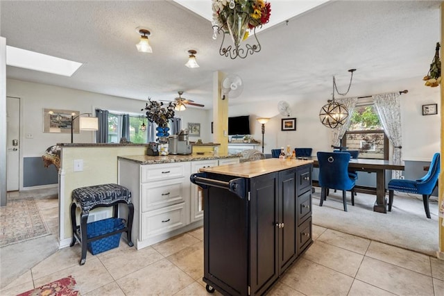 13613 Lowell Ave, Grandview, MO 64030 - kitchen featuring a center island, white cabinets, a desk, a textured ceiling, and dark cabinetry