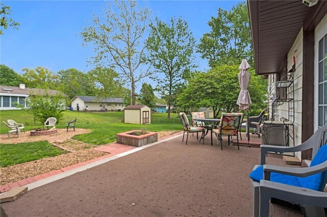 13613 Lowell Ave, Grandview, MO 64030 - view of patio / terrace featuring an outdoor fire pit, a storage unit, outdoor dining space, and an outdoor structure