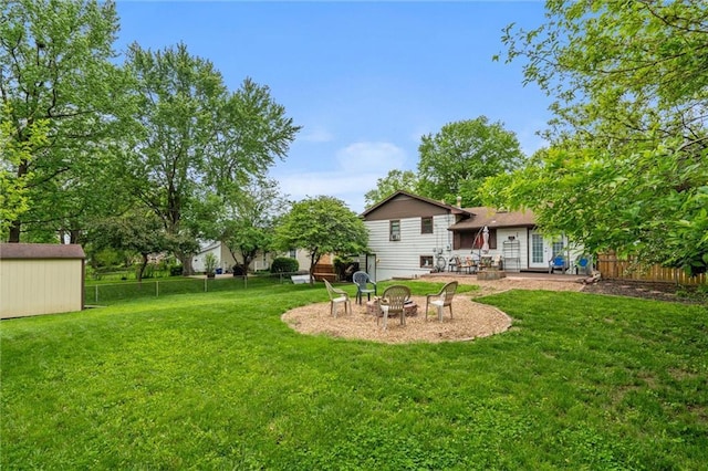 13613 Lowell Ave, Grandview, MO 64030 - view of yard with an outdoor fire pit, an outbuilding, a storage shed, and a patio