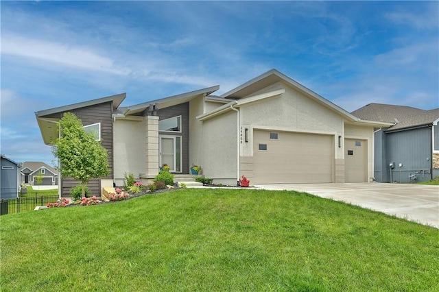 view of front facade with concrete driveway, an attached garage, fence, and a front yard