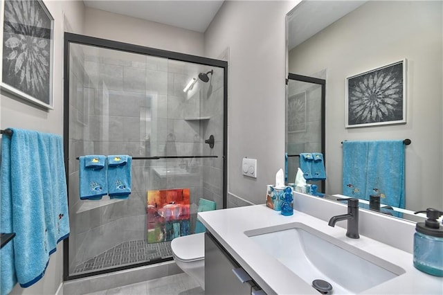 bathroom featuring vanity, a stall shower, and toilet