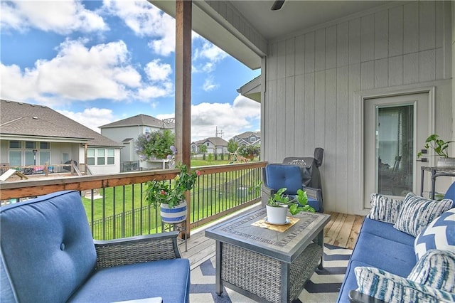 view of wooden balcony featuring ceiling fan, a residential view, and a deck