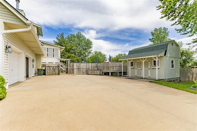 24545 W 54th St, Shawnee, KS 66226 - view of patio featuring a storage shed, fence, an outbuilding, a garage, and concrete driveway