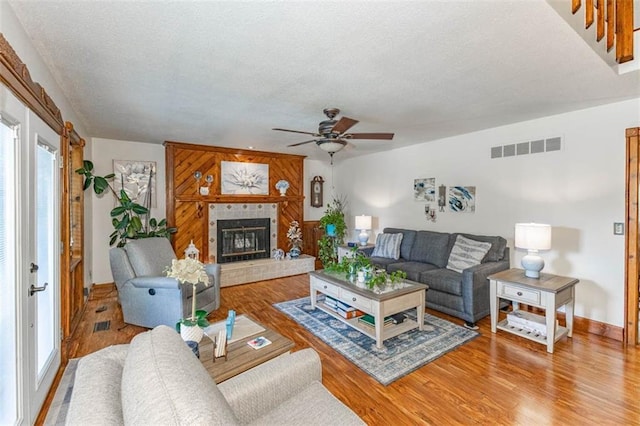 24545 W 54th St, Shawnee, KS 66226 - living area featuring a textured ceiling, ceiling fan, wood finished floors, baseboards, and a fireplace