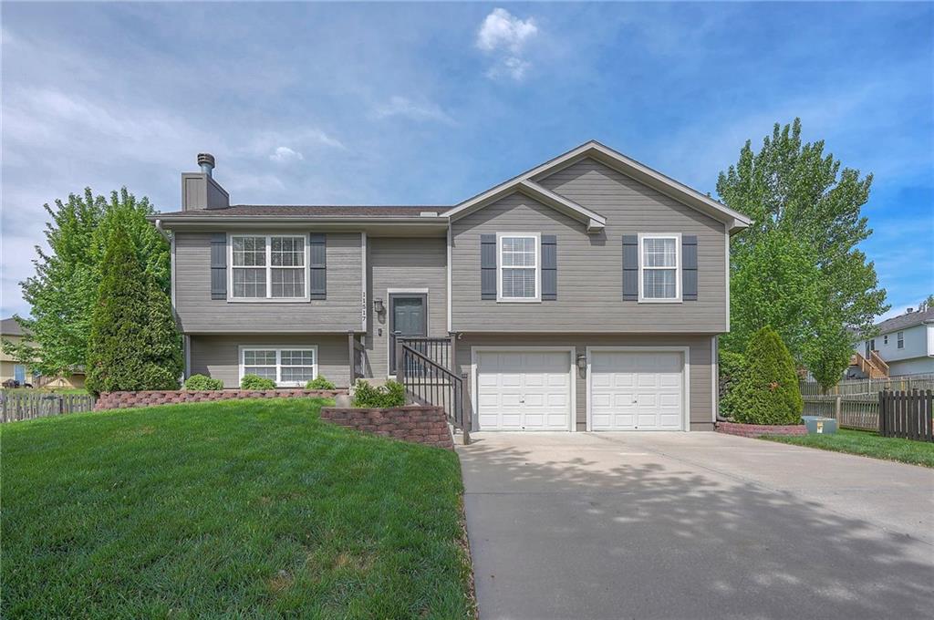 11517 N Laurel Ct, Kansas City, MO 64157 - bi-level home with a chimney, concrete driveway, and an attached garage