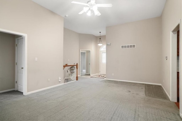 carpeted spare room with visible vents, a ceiling fan, and baseboards