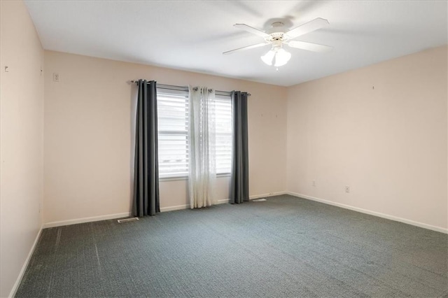empty room featuring ceiling fan, baseboards, and carpet
